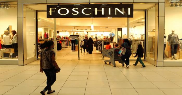 FILE PHOTO: A shopper walks past a Foschini store at a shopping centre in Lenasia, south of