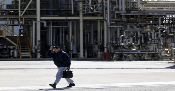 Worker walks past a factory at the Keihin industrial zone in Kawasaki