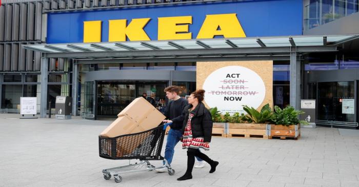 FILE PHOTO: Customers walk by a placard reading 