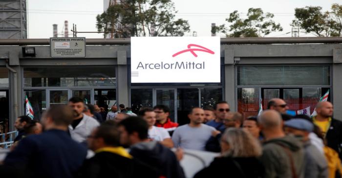 People wait for the arrival of Italian Prime Minister Giuseppe Conte outside the Ilva steel