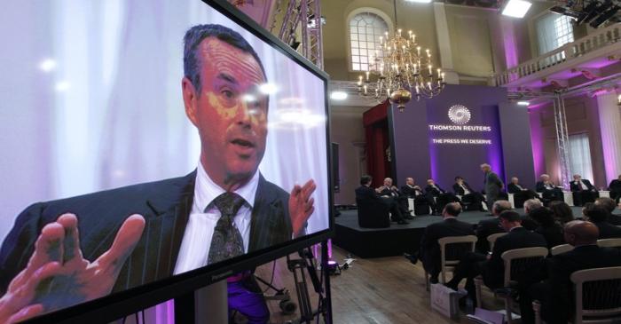 Financial Times Editor Barber is seen on a television screen as he responds to a question at a