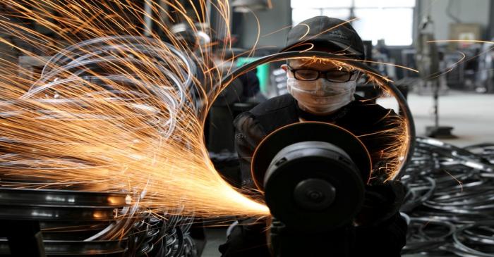 FILE PHOTO: Worker welds a bicycle steel rim at a factory manufacturing sports equipment in