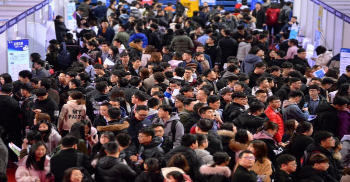 Students are seen at a job fair for graduates at a university in Shenyang, Liaoning