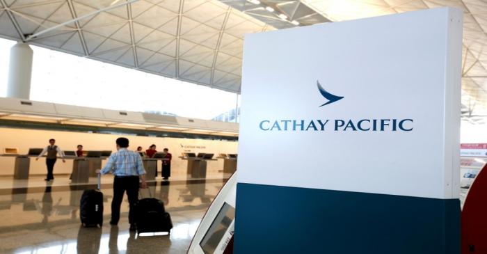 A passenger walks to the First Class counter of Cathay Pacific Airways at Hong Kong Airport in