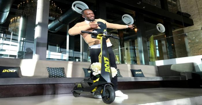 Olympic gold medallist Usain Bolt poses for a photograph as he shows off an electric scooter at