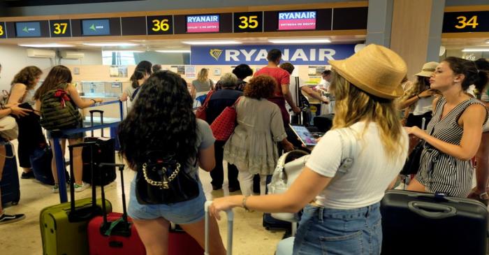 FILE PHOTO: Ryanair passengers line up to check in their luggage at the airport, during a