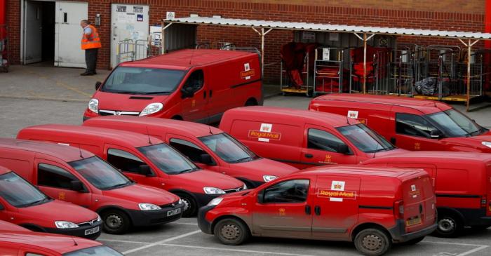 FILE PHOTO: A Royal Mail postal worker stands in the yard of a sorting office in Altrincham,