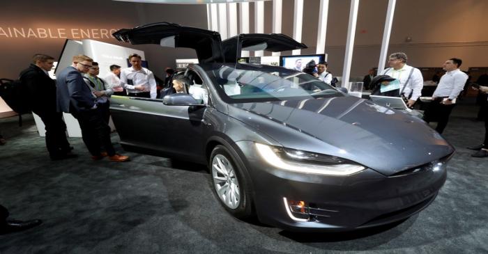 Attendees look over a Tesla Model X powered by Panasonic batteries at the Las Vegas Convention