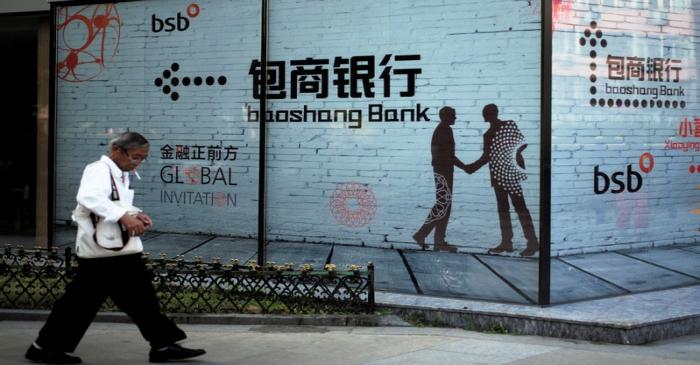 Man walks past a building with an advertisement of Baoshang Bank in Beijing