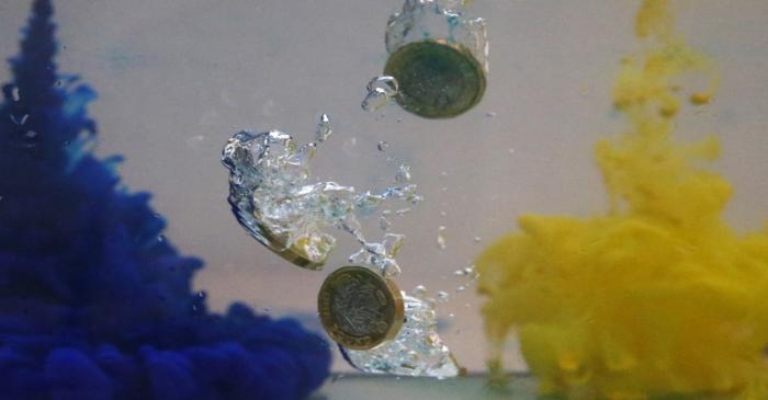 UK pound coins plunge into water coloured with the European Union flag colours in this