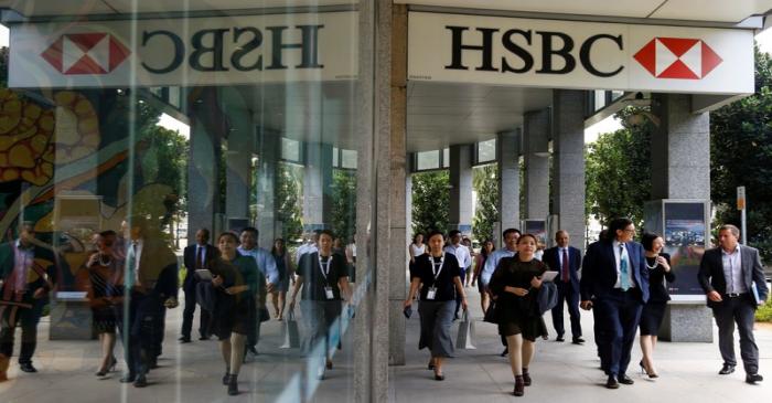 People walk past a HSBC signage in Singapore