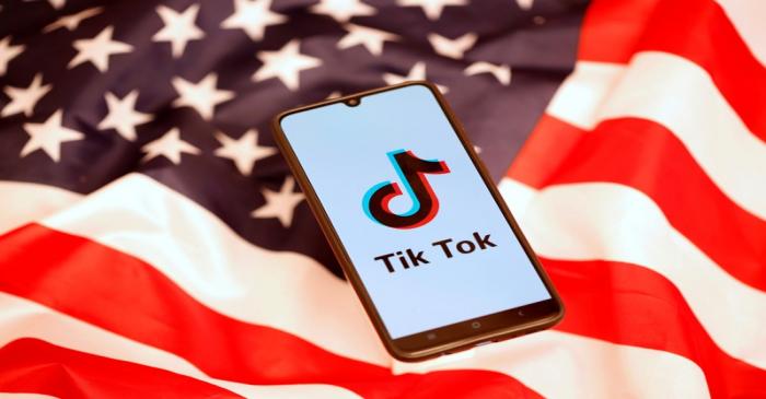 FILE PHOTO: TikTok logo is displayed on the smartphone while standing on the U.S. flag in this