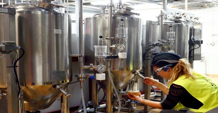 A worker checks beer quality at Anheuser-Busch InBev brewery in Leuven