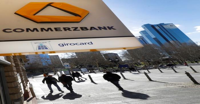 FILE PHOTO: A sign for an ATM of Commerzbank is seen next to the headquarters of Deutsche Bank