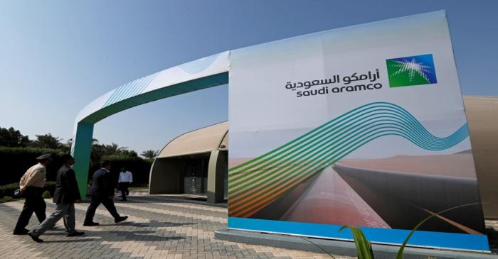 FILE PHOTO: Logo of Aramco is seen as security personnel walk before the start of a press