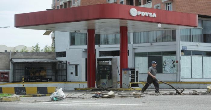 A man walks past a closed gas station of the state oil company PDVSA in San Cristobal