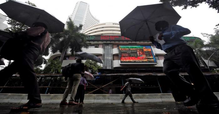 FILE PHOTO:  People walk past at a screen displaying India's Finance Minister Nirmala