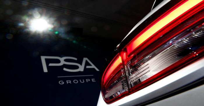 A PSA Group logo is seen behind a car displayed during French carmaker's news conference as