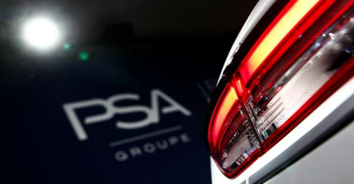 A PSA Group logo is seen behind a car displayed during French carmaker's news conference as