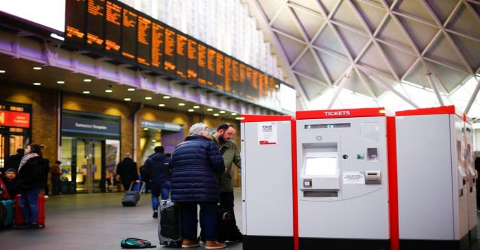 Commuters use ticket machines inside King's Cross Railway Station in London