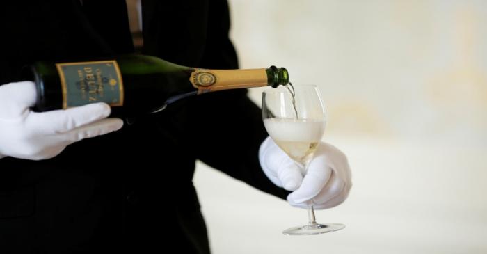 FILE PHOTO: An employee serves a glass of Champagne during the traditional wine harvest at the