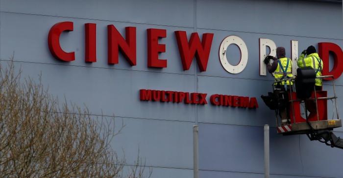 FILE PHOTO Workers repair a sign at a Cineworld cinema in Bradford northern England.