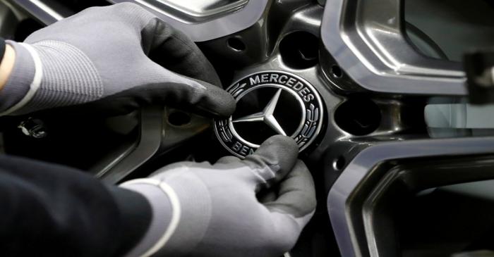 FILE PHOTO: An employee of German car manufacturer Mercedes Benz installs a hubcap at a A-class