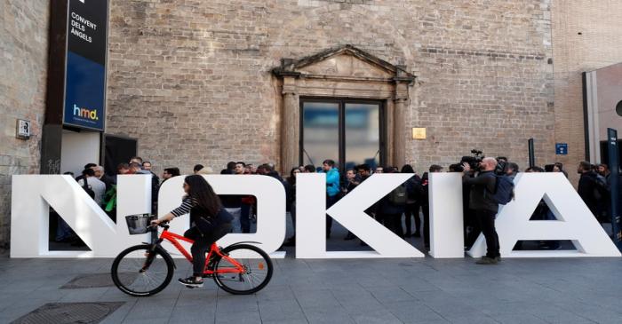 FILE PHOTO: A cyclist rides past a Nokia logo during the Mobile World Congress in Barcelona