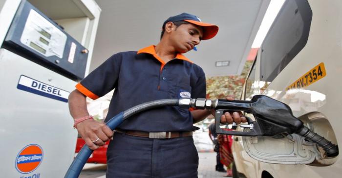 FILE PHOTO: A worker fills a vehicle with diesel at a fuel station in the western Indian city