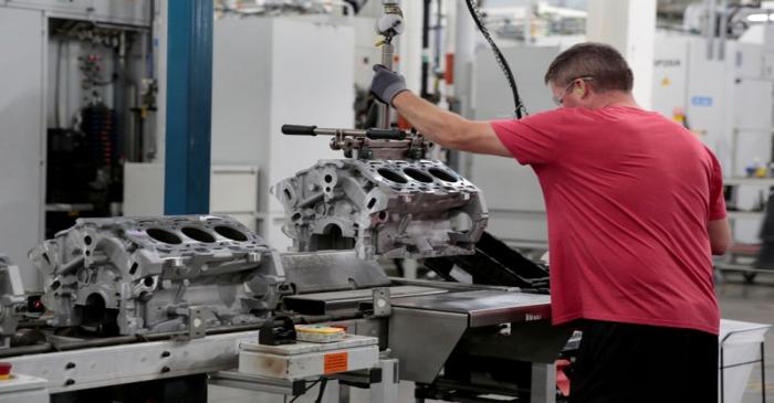 FILE PHOTO: A General Motors assembly worker loads engine block castings on to the assembly