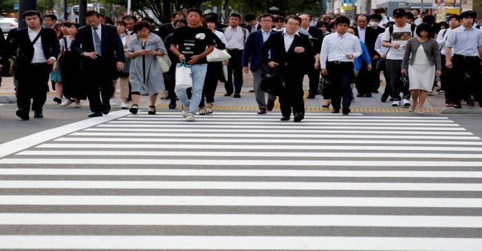 FILE PHOTO: Pedestrians make their way in a business district in Tokyo