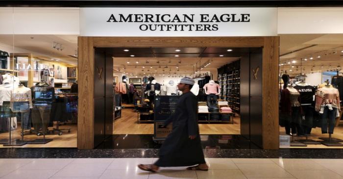 An Omani man passes in front of an American fashion brand, American Eagle Outfitters in City