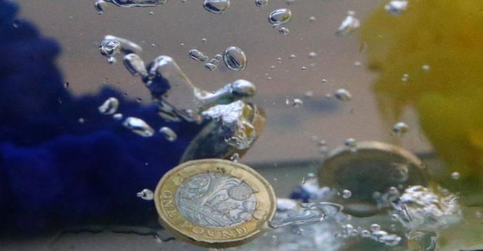 UK pound coins plunge into water coloured with the European Union flag colours in this