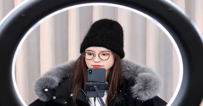Online Chinese celebrity and store owner Zhang Dayi checks comments from viewers on a phone