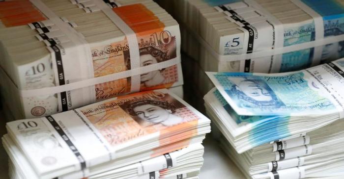 Wads of British Pound Sterling banknotes are stacked in piles at the Money Service Austria
