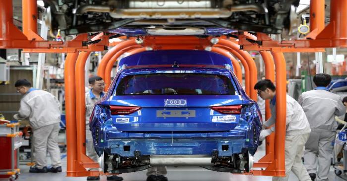 Workers work on an assembly line manufacturing Audi Q3 cars at the FAW-Volkswagen Tianjin plant