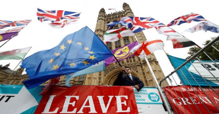 An anti-Brexit protester waves an EU flag outside the Houses of Parliament in London