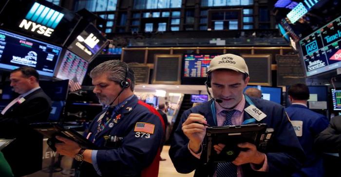FILE PHOTO: Traders work on the floor at the New York Stock Exchange (NYSE) in Manhattan, New