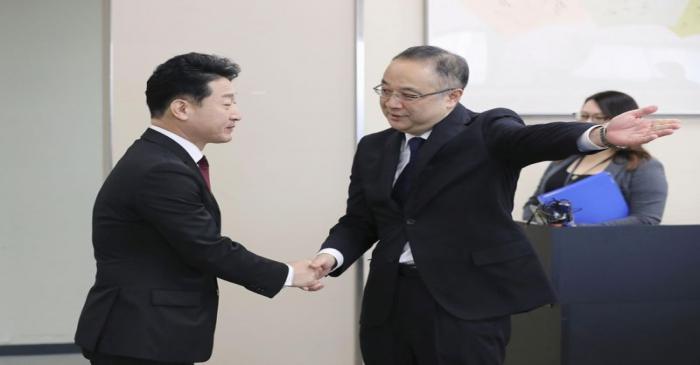 Japan's Director General for Trade Control Department Iida shakes hands with South Korea's