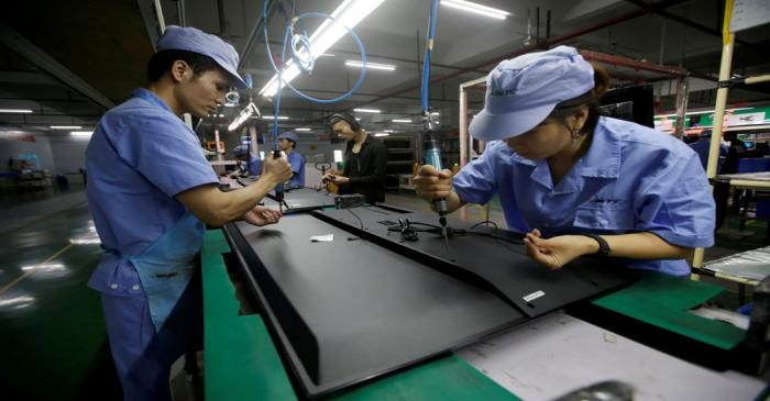 FILE PHOTO: Employees work on the production line of a television factory under Zhaochi Group