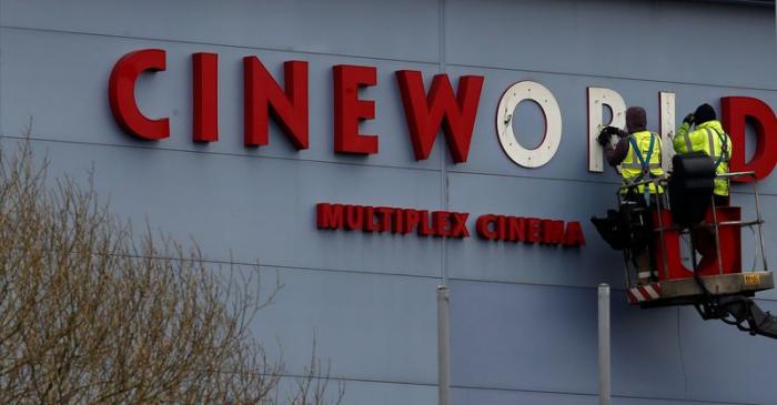 FILE PHOTO Workers repair a sign at a Cineworld cinema in Bradford northern England.