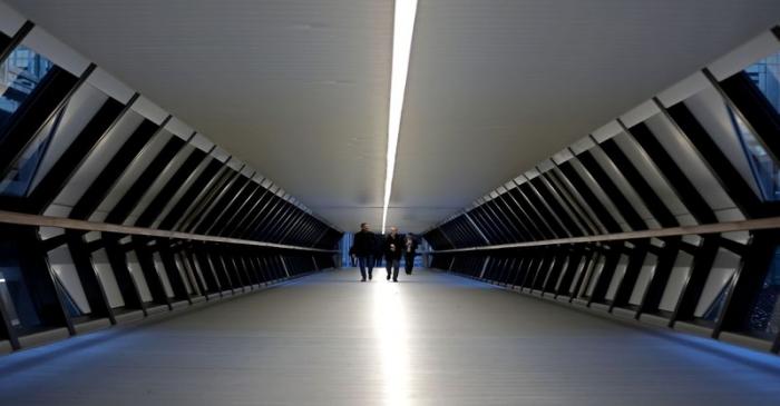 FILE PHOTO: People walk through the Crossrail Place Bridge in the Canary Wharf financial