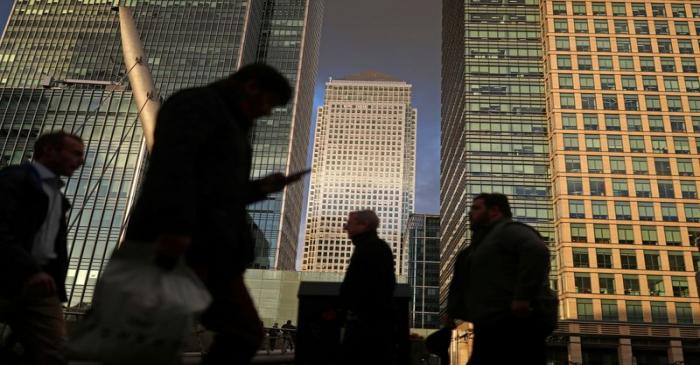 FILE PHOTO: People walk through the Canary Wharf financial district of London