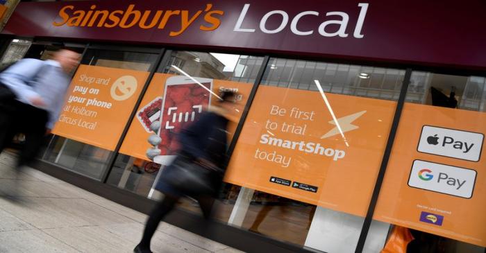 FILE PHOTO: Shoppers walk past the first 'till-free' Sainsbury's store in London, Britain