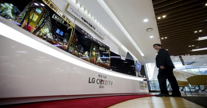 An employee stands in front of LG Electronics' television sets, which are made with LG Display