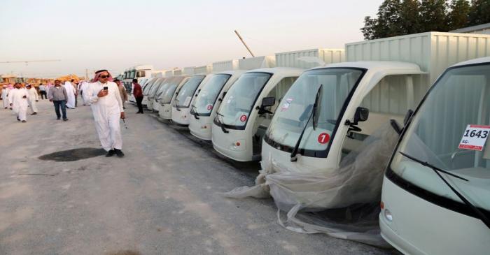FILE PHOTO: Man looks at vehicles belonging to billionaire Maan al-Sanea and his company as