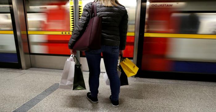 FILE PHOTO: A woman carries her shopping bags before boarding a train on the London Underground