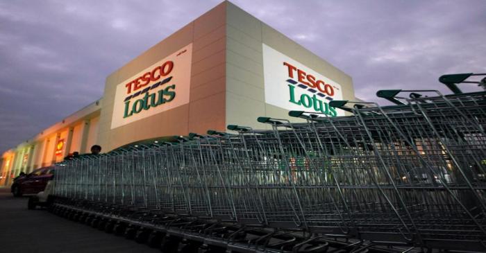 FILE PHOTO: A worker pushes trolleys at a Tesco Lotus supermarket in Bangkok