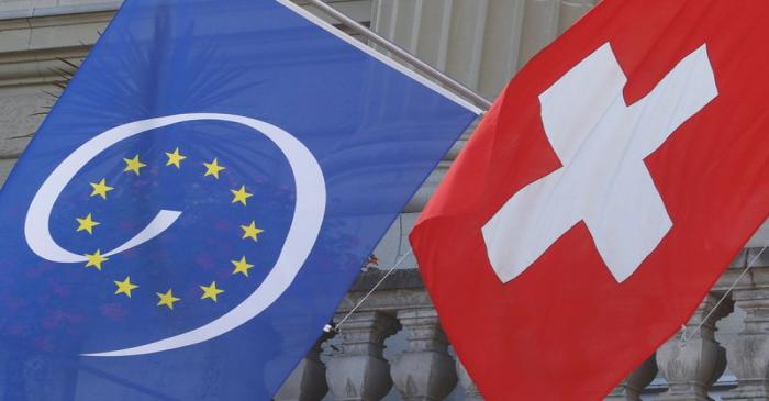 FILE PHOTO:  Switzerland's national flag flies beside the one of the Council of Europe at the