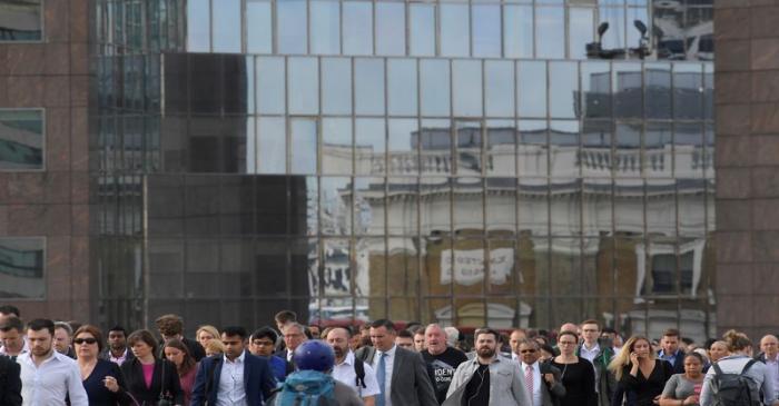 Workers cross London Bridge during the morning rush hour in London